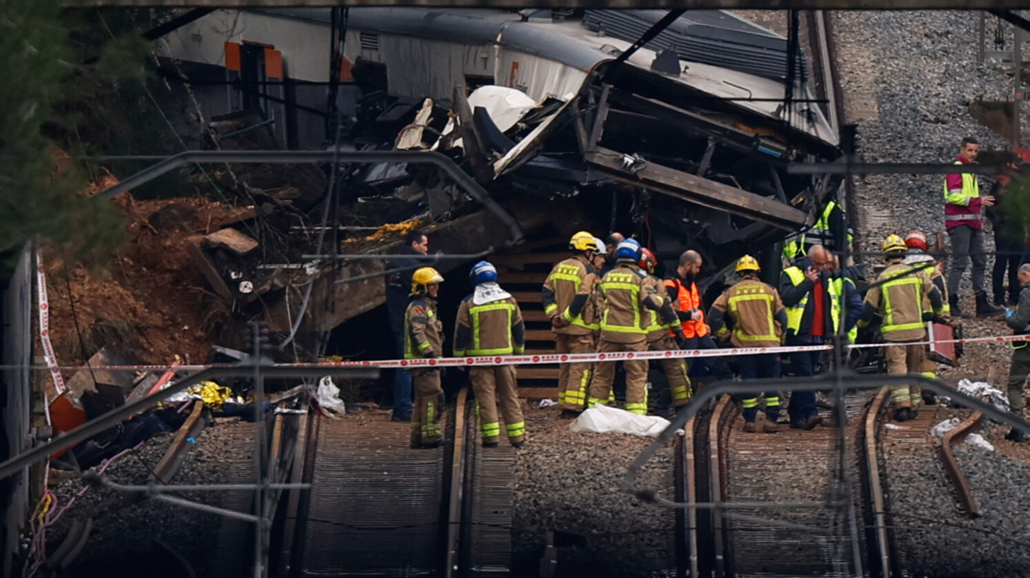 Полицаи и огнеборци инспектират причинените щети от дерайлирал влак след срутването на подпорна стена в град Хелида, близо до Барселона.