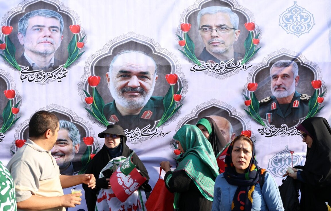 Иранци пред билборд със снимките на висши военни, убити при израелските атаки тази седмица, Техеран, 14 юни 2025 г.