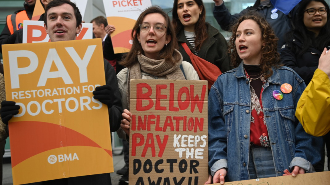 Младши лекари държат плакати, докато стачкуват пред болницата на Университетския колеж в Лондон, 11 април 2023 г.