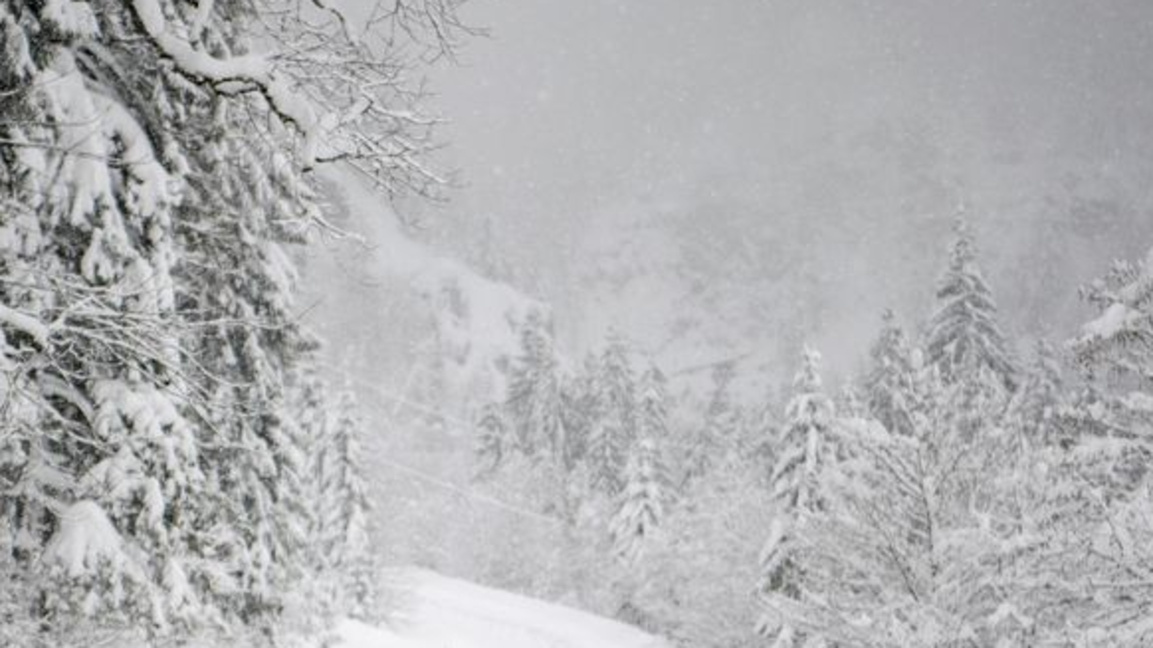 Мъж снима затворен път със знак, предупреждаващ за опасност от лавини край Унтертаурен в австрийската провинция Залцбург.